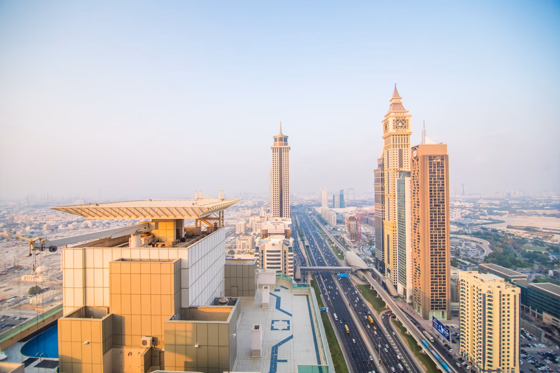 Skyline of Dubai, United Arab Emirates, featuring high-rise buildings and Sheikh Zayed Road under hazy summer conditions during August.