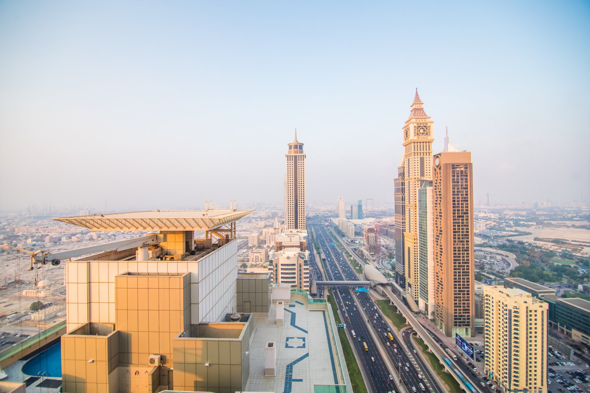 Skyline of Dubai, United Arab Emirates, featuring high-rise buildings and Sheikh Zayed Road under hazy summer conditions during August.