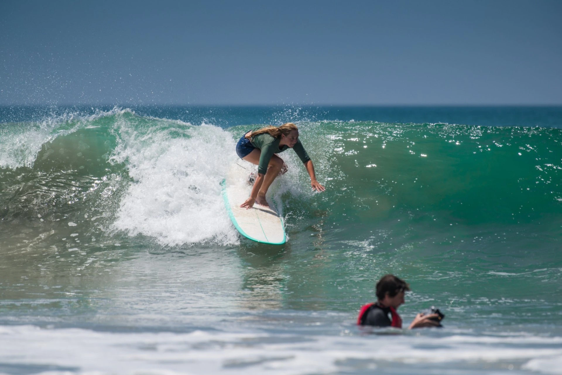 Surfer riding a rolling Atlantic wave at San Sebastián Beach, enjoying clear blue waters and ideal surfing conditions in Spain.