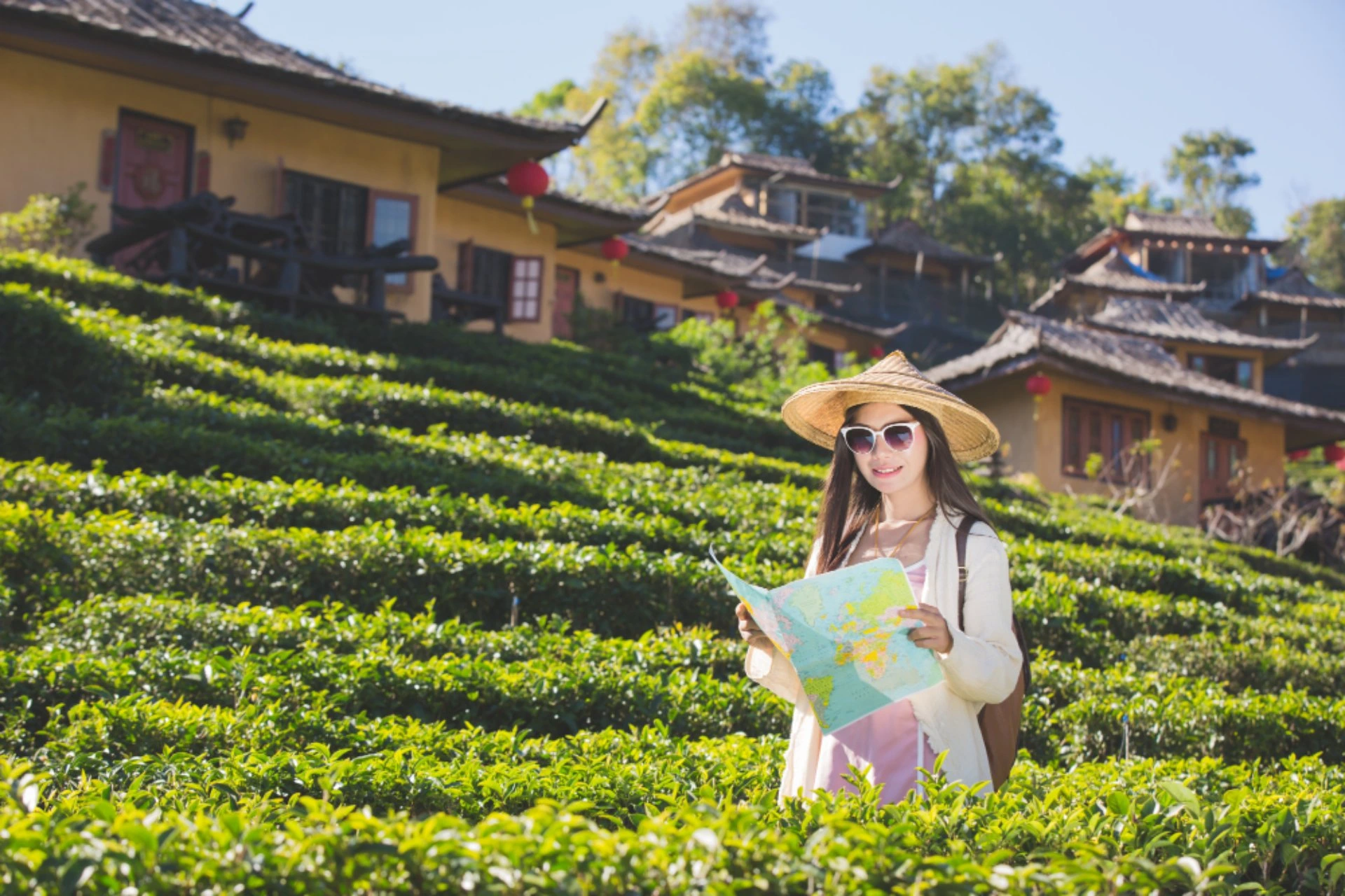 Traveller holding a map while exploring the scenic countryside near Hoi An in Vietnam during October, surrounded by lush greenery and traditional village houses.