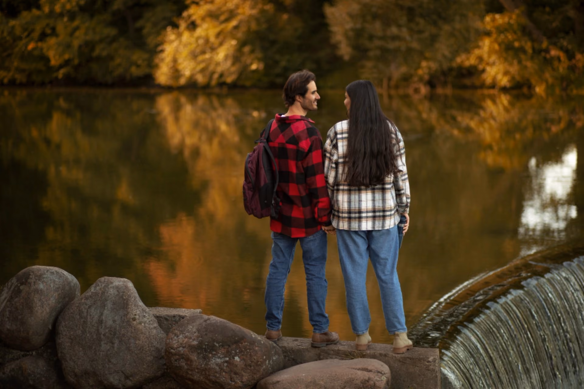 A couple standing by a serene lakeside surrounded by lush greenery, representing Sri Lanka as an ideal destination for nature lovers, couples, and relaxing holidays.