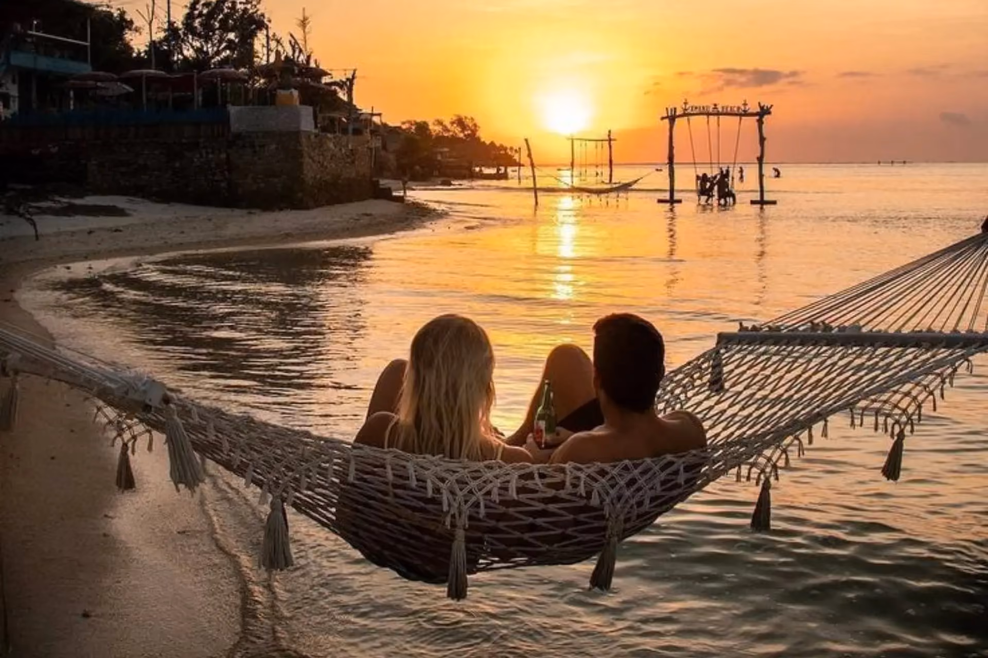 Couple relaxing in a hammock at sunset on Gili Trawangan — a romantic highlight of a 7 day trip in August.