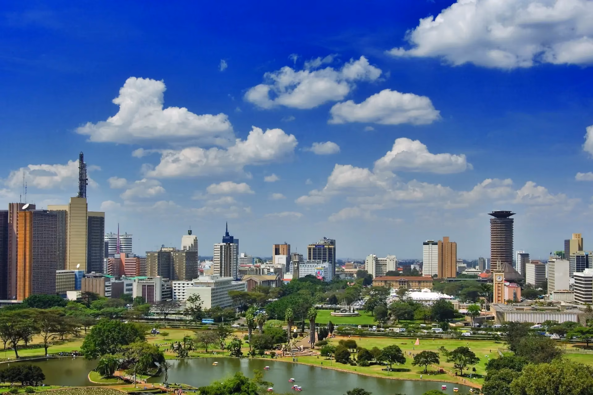 Nairobi skyline with Uhuru Park in the foreground under a bright blue sky