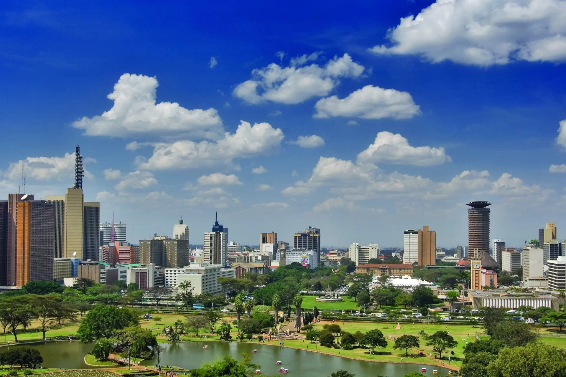 Nairobi skyline with Uhuru Park in the foreground under a bright blue sky
