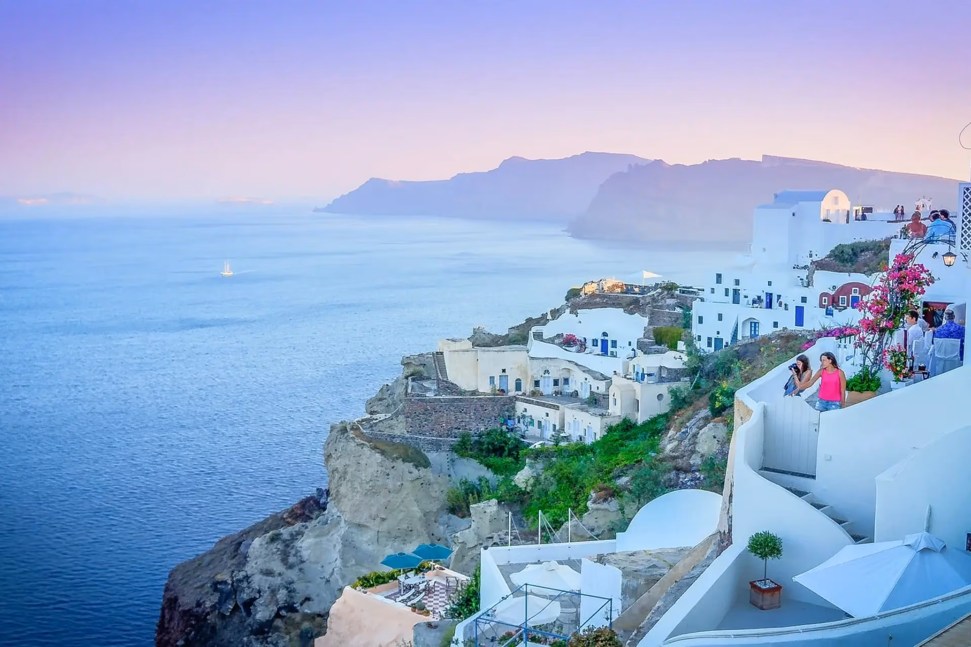 Whitewashed homes cascading down Santorini's cliffs above the sparkling Aegean Sea.