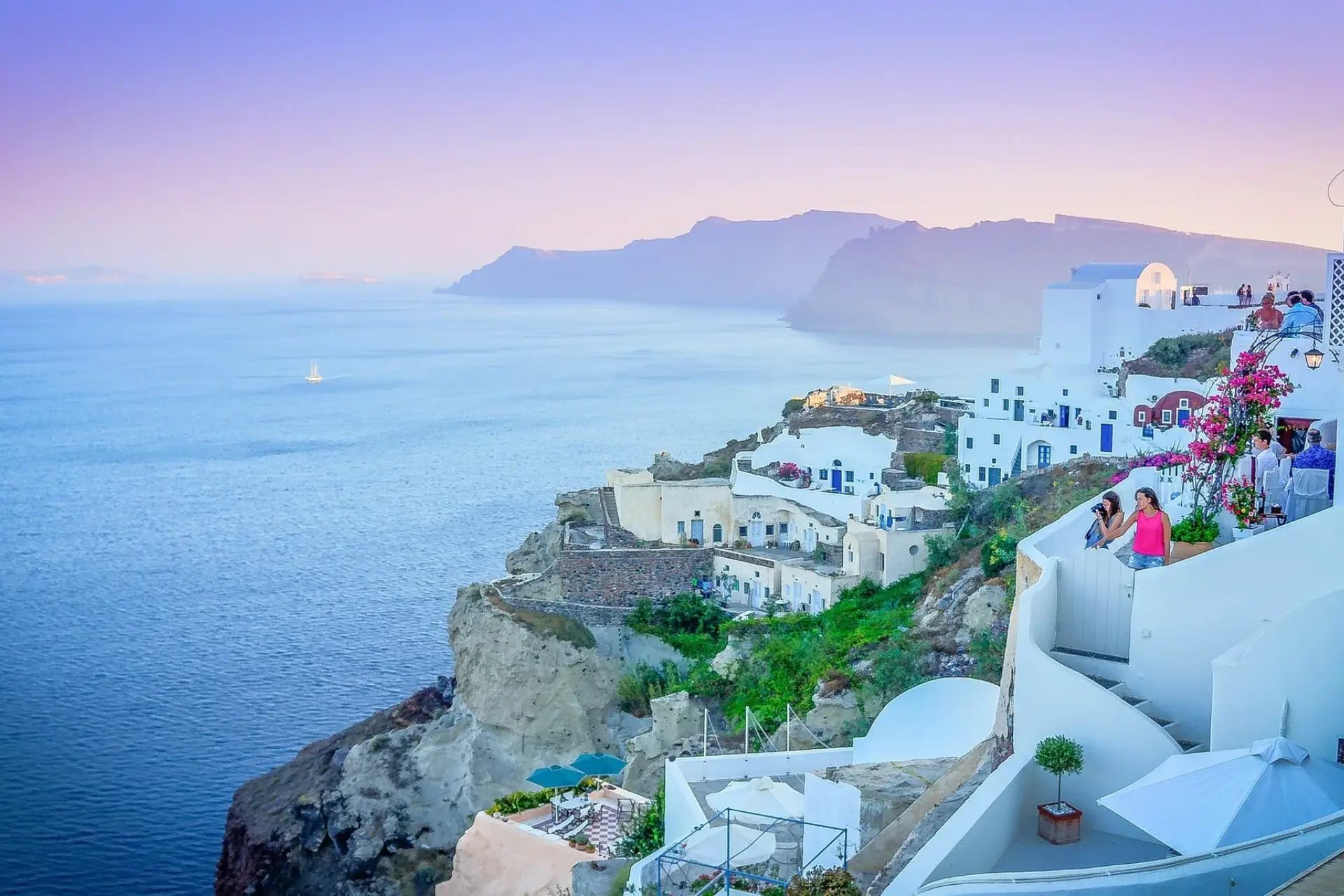Whitewashed homes cascading down Santorini's cliffs above the sparkling Aegean Sea.