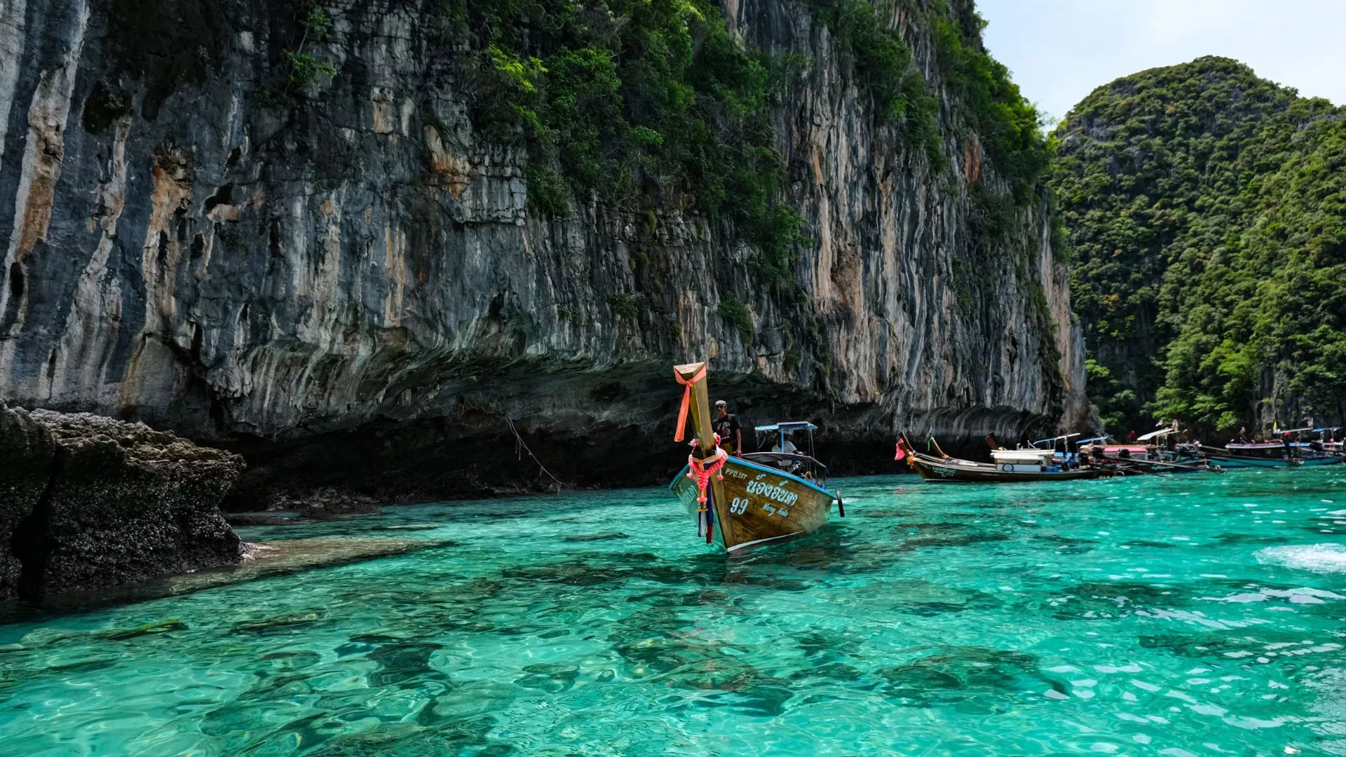 Longtail boat near limestone cliffs in the Phi Phi Islands