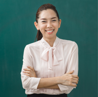 Camille Chrysostom smiling with arms crossed in front of chalkboard