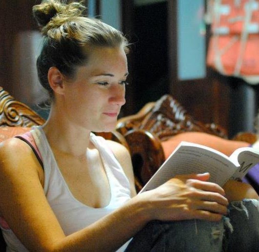 Meghan Hausdorf reading a book while seated in a chair