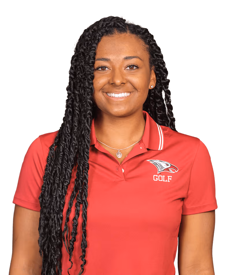 Smiling woman with long braided hair wearing a red golf polo shirt with an eagle logo.