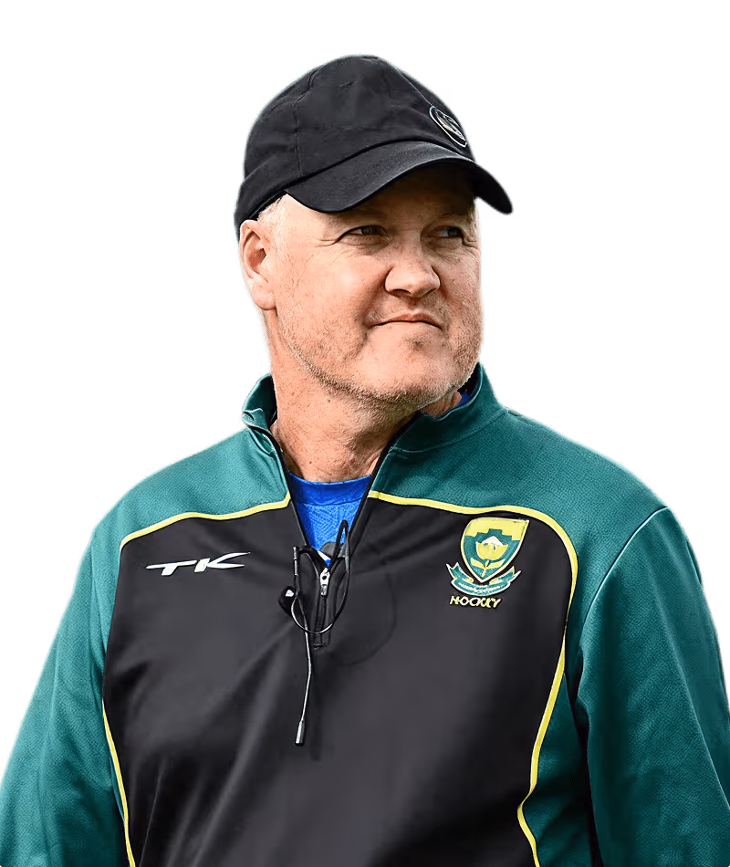 Man wearing a black cap and green and black jacket with a hockey emblem, looking to the side.