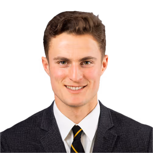 Portrait of a smiling young man with short brown hair wearing a black suit, white shirt, and striped black and yellow tie.
