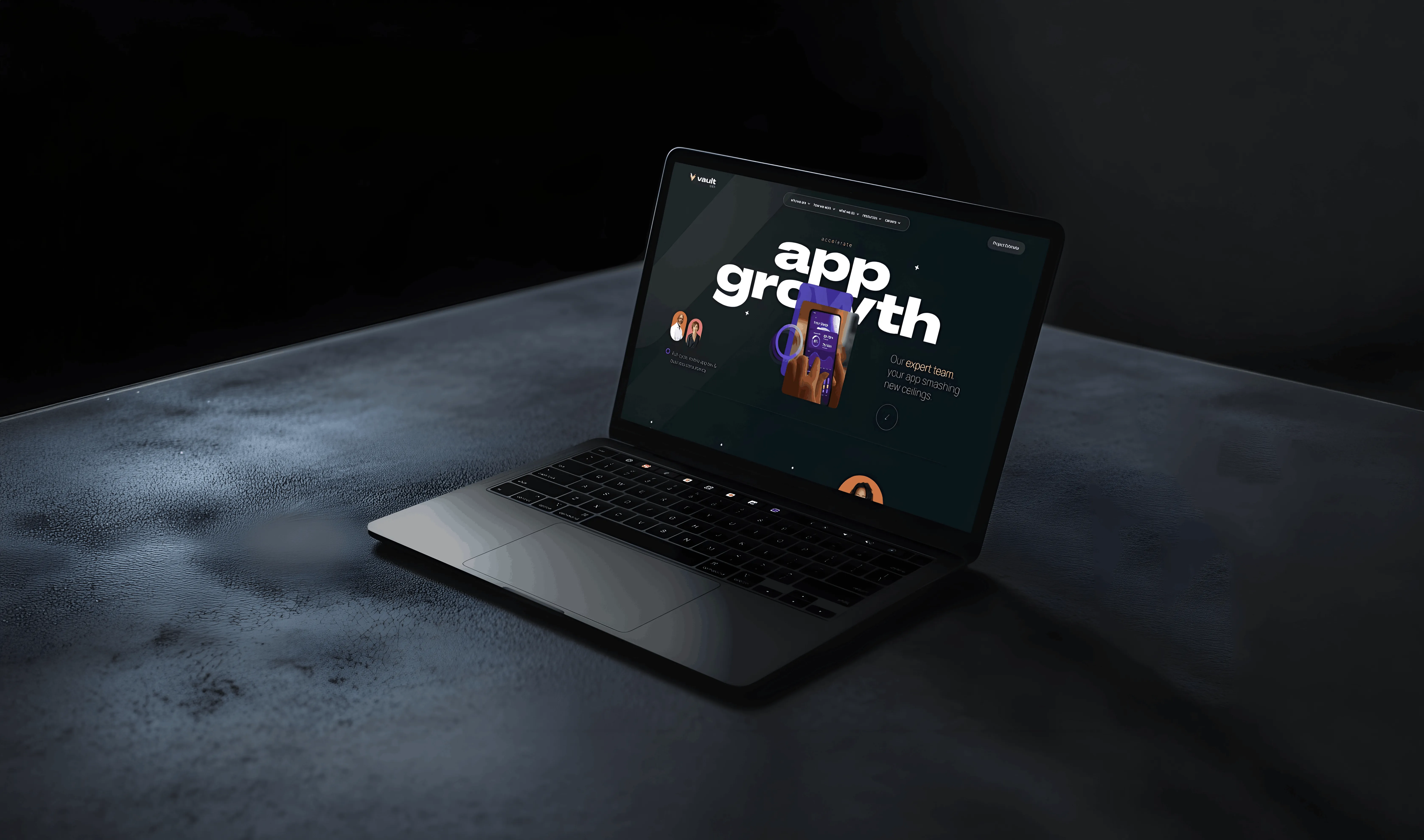 Laptop on dark textured surface displaying a webpage with the text 'app growth' and a hand holding a smartphone.