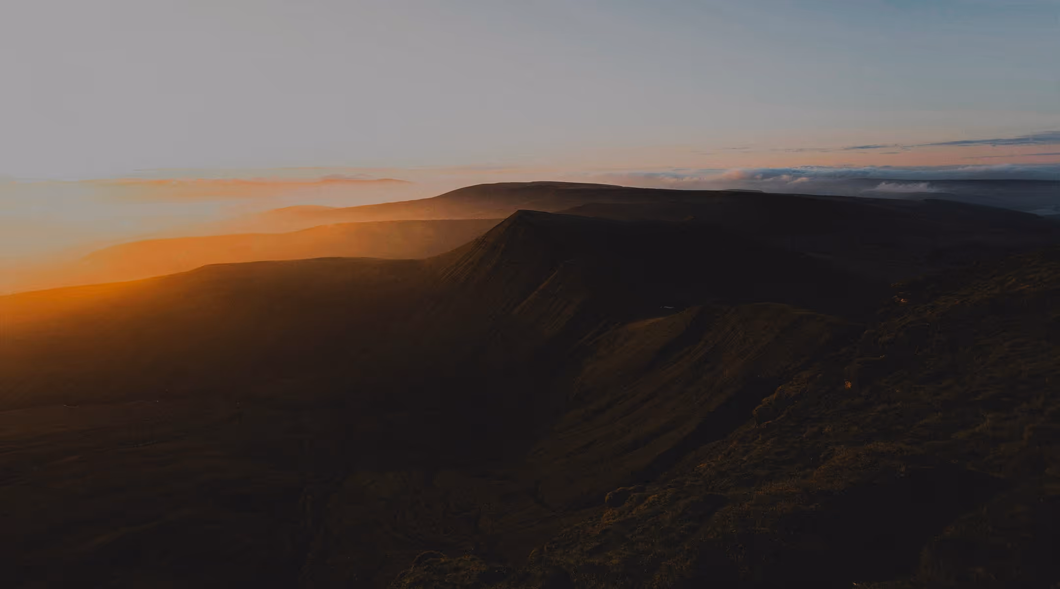 The sun is setting over a mountain range.