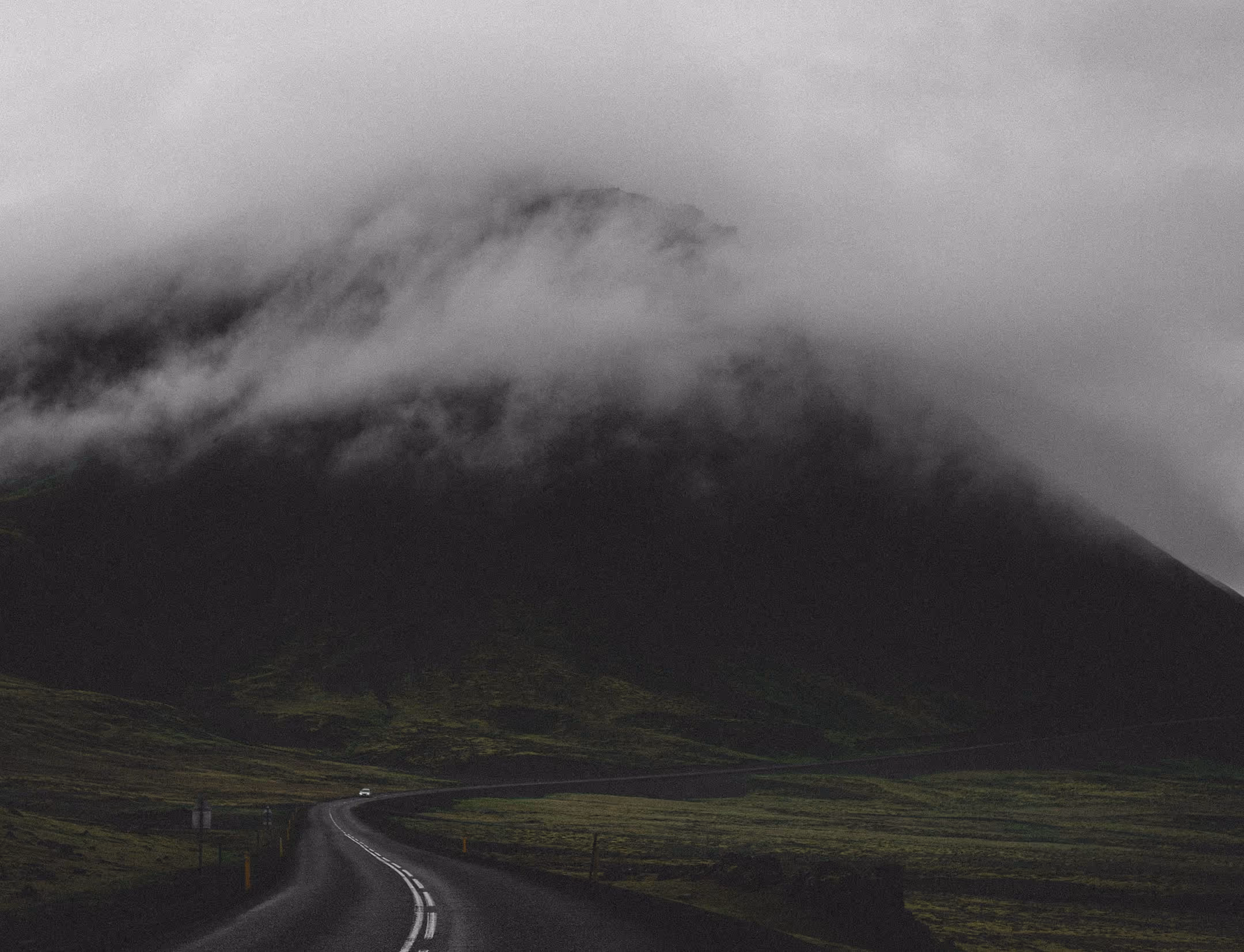 A long road with a mountain in the background.