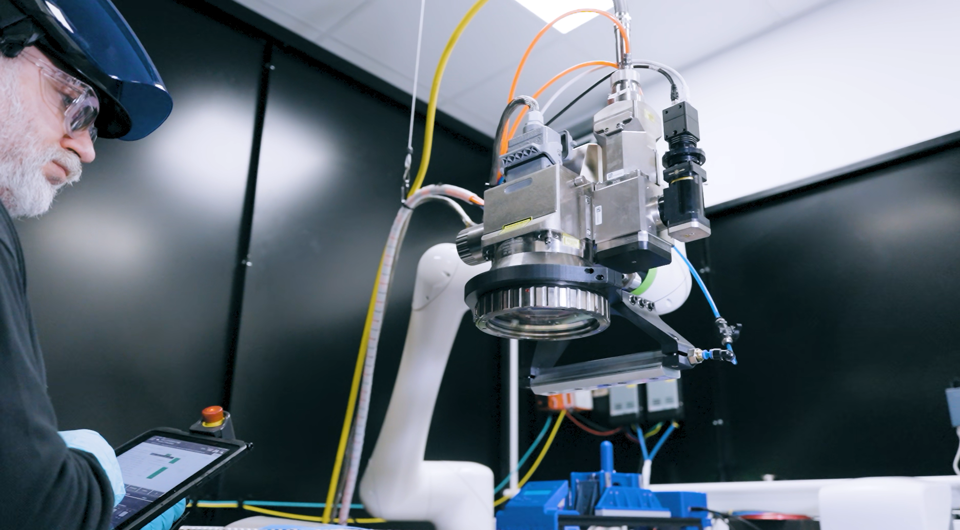 IONETIC engineer with a tablet operating a robotic pick-and-place head on the Arc fabrication pilot line.