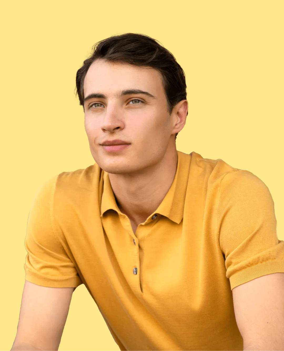 A young man in a yellow shirt is posing for a picture.