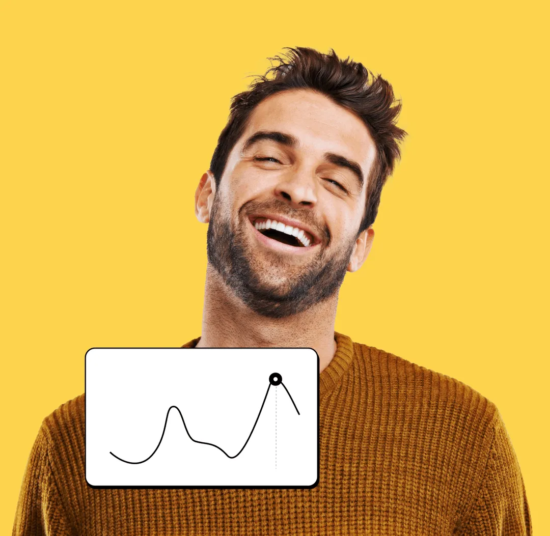 A man smiling and holding a white board with a graph on it.
