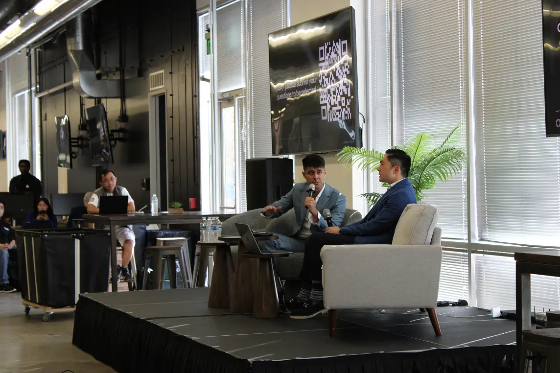Two speakers talking on stage during a panel discussion