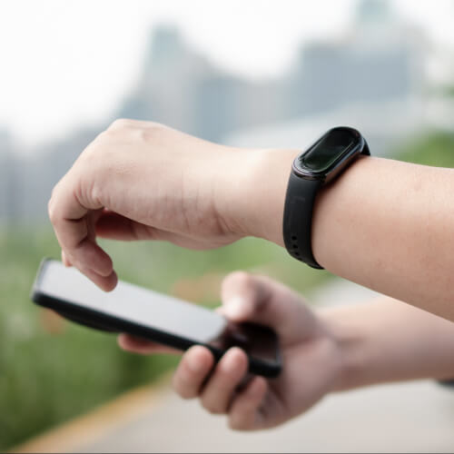 Person using phone while wearing a black smartwatch.