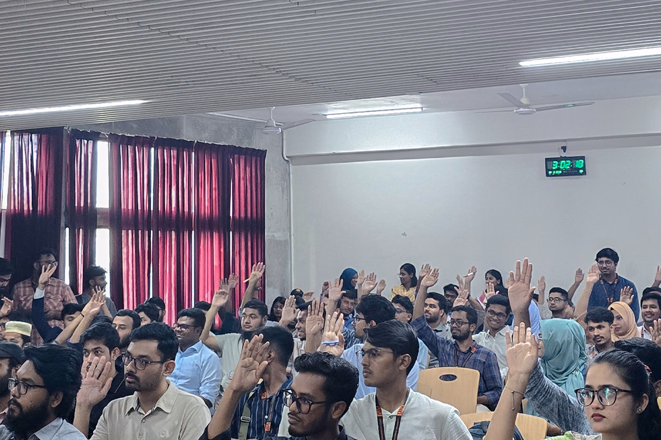 People raising their hands during an interactive workshop or seminar.