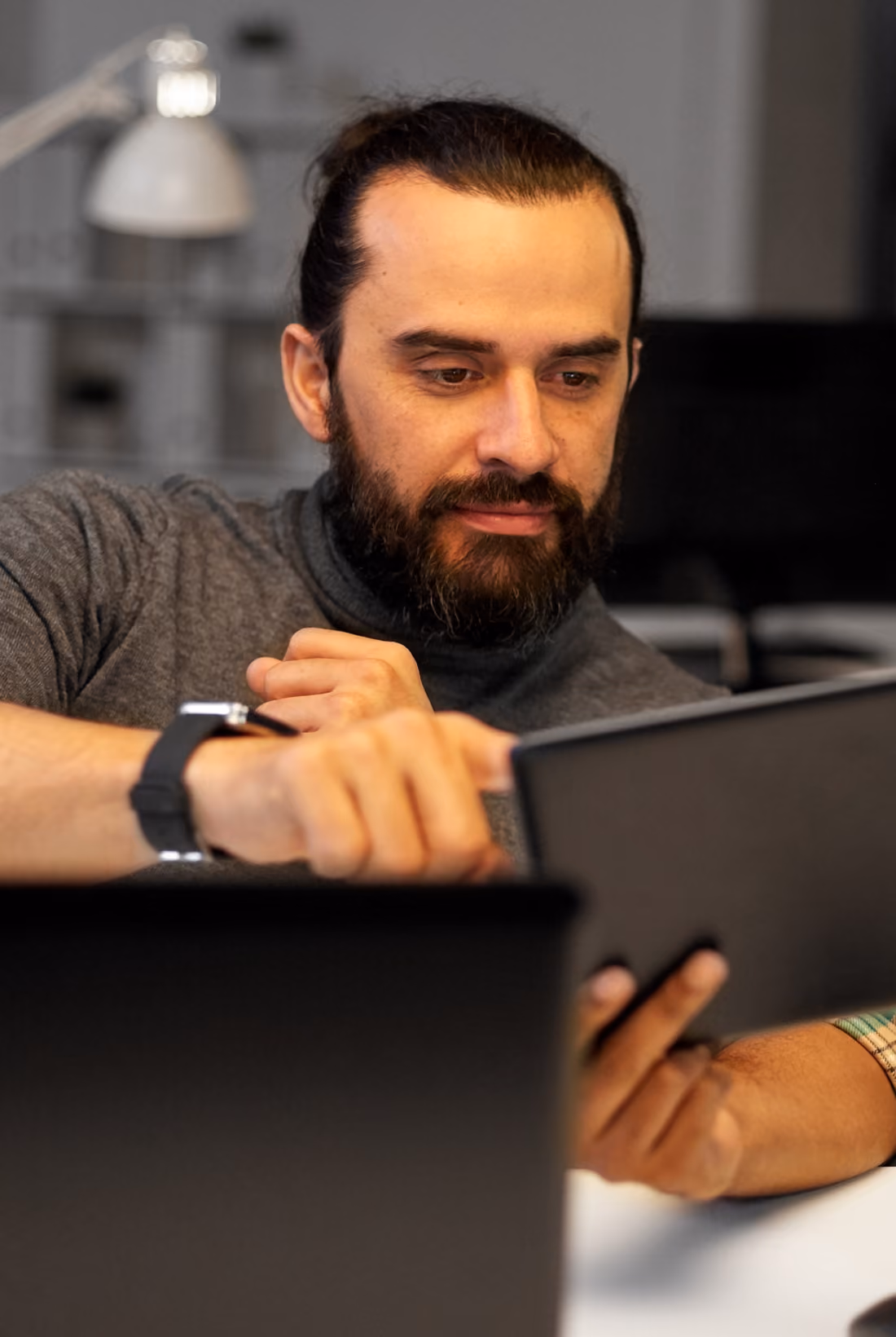 Person pointing at a tablet screen during a discussion.
