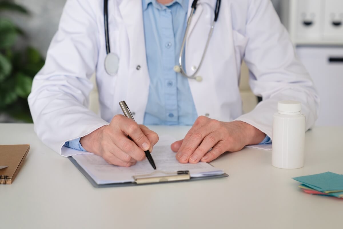 clinician writing on chart