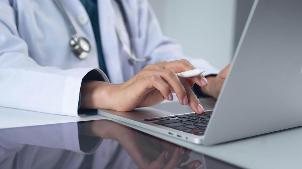 doctor typing on laptop