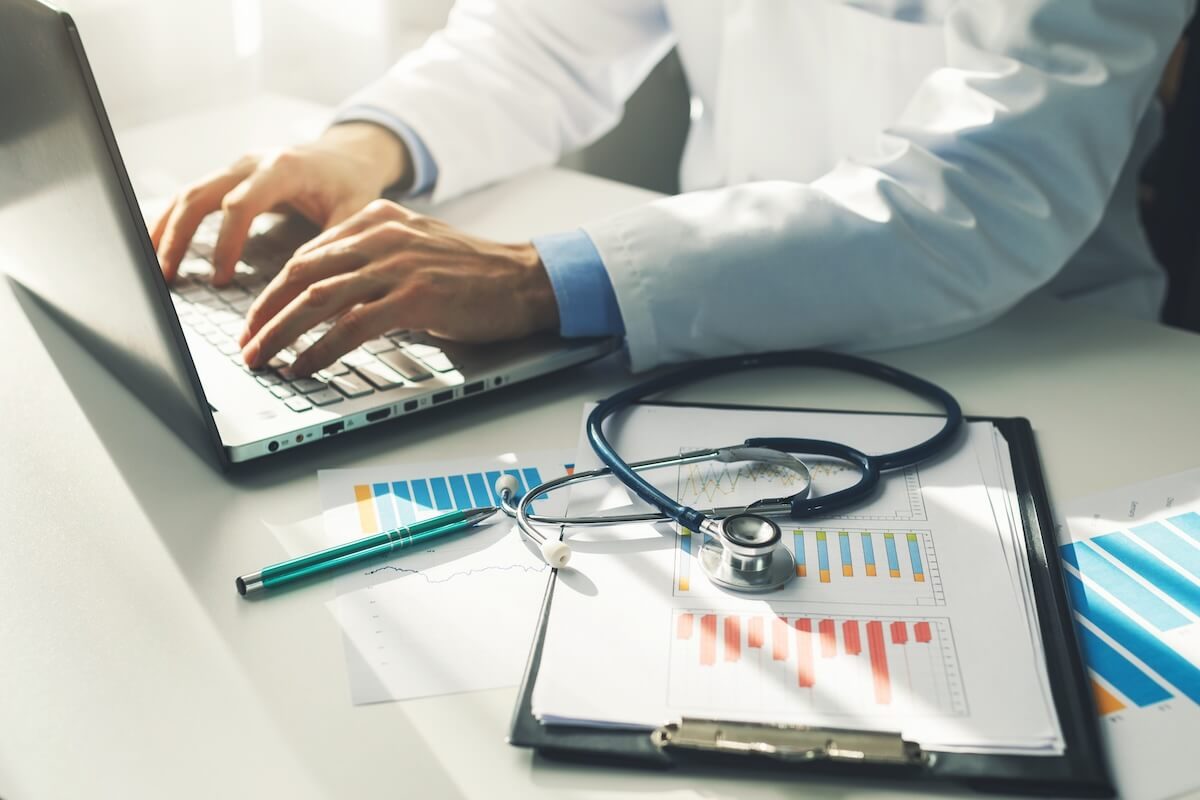 doctor typing on laptop