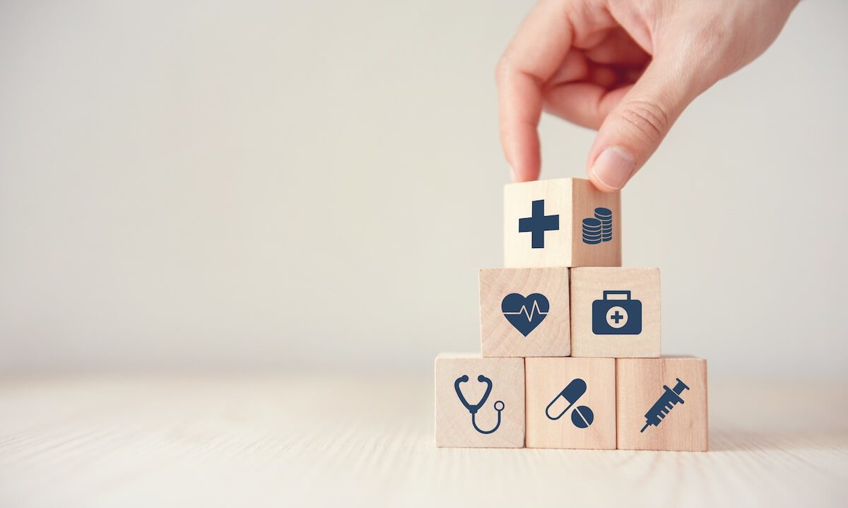 hand placing healthcare blocks.jpeg