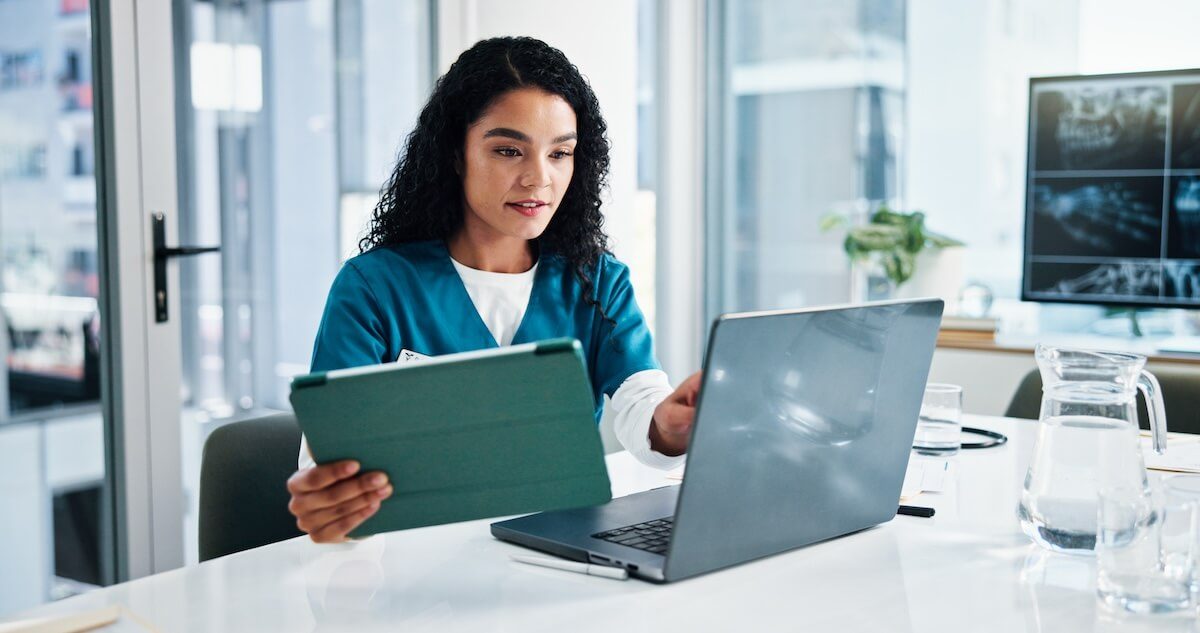 clinician using tablet and laptop
