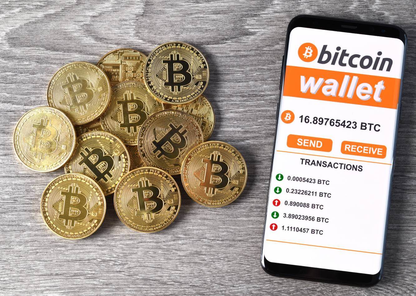 bitcoin wallet displayed on a smartphone next to gold bitcoins