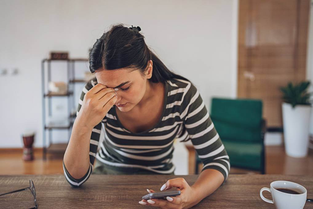 job hunting scam victim visibly upset while sitting at a home table