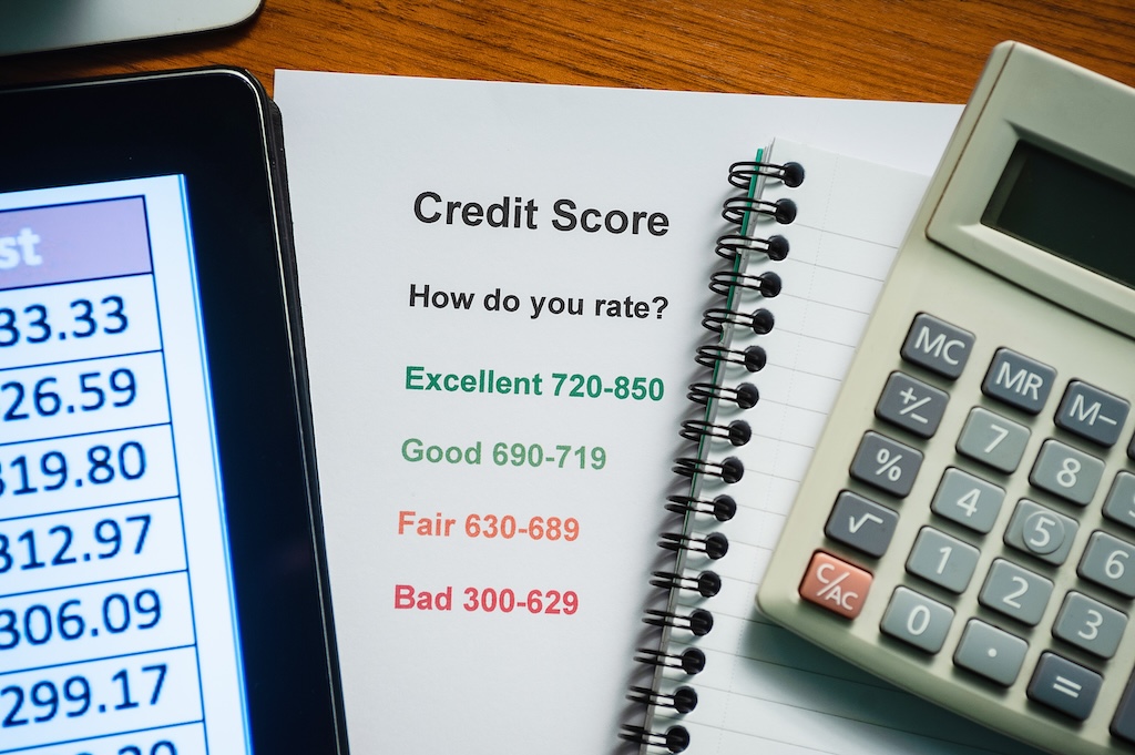 A paper showing credit scores next to a calculator