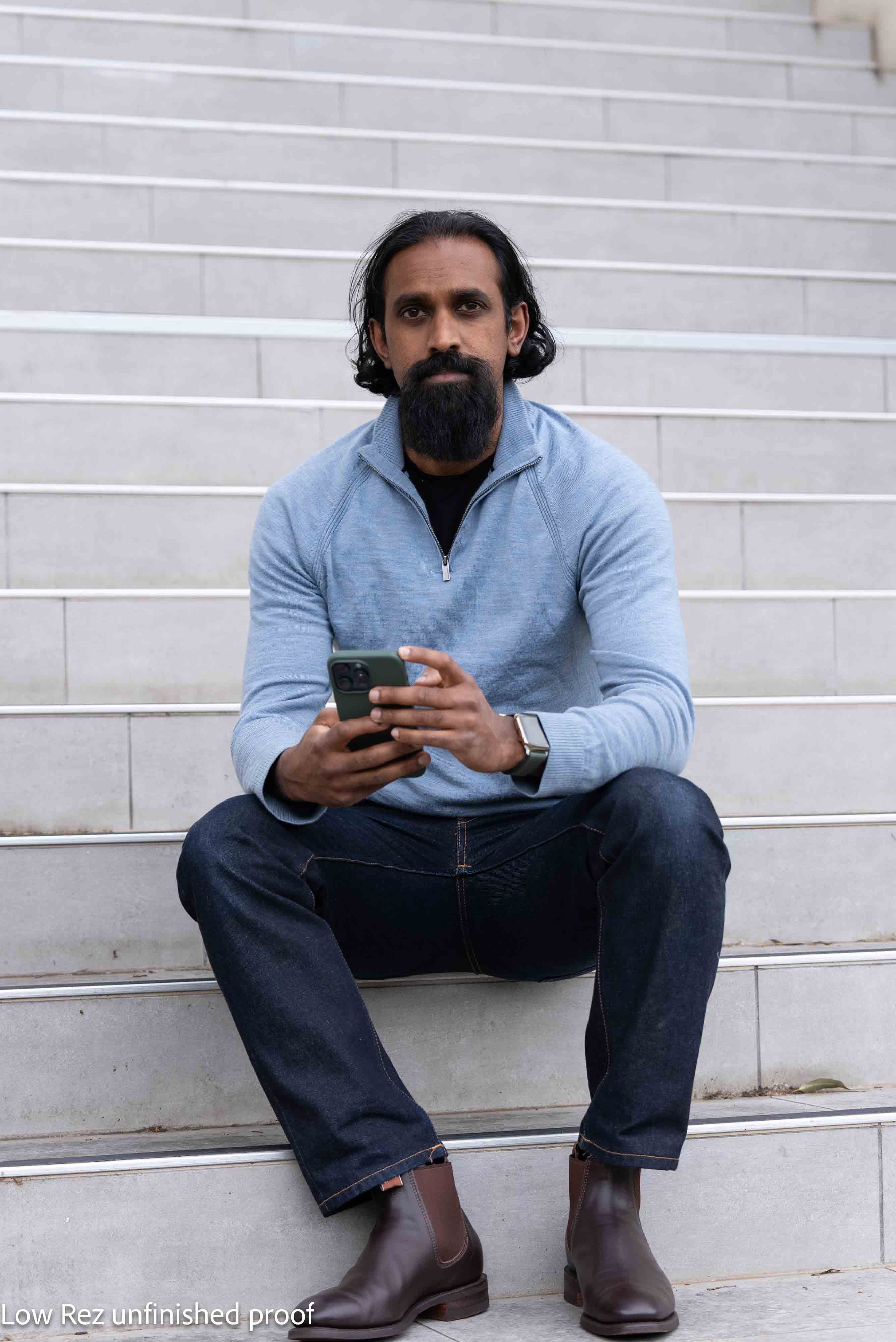 Shane sitting on steps, using phone