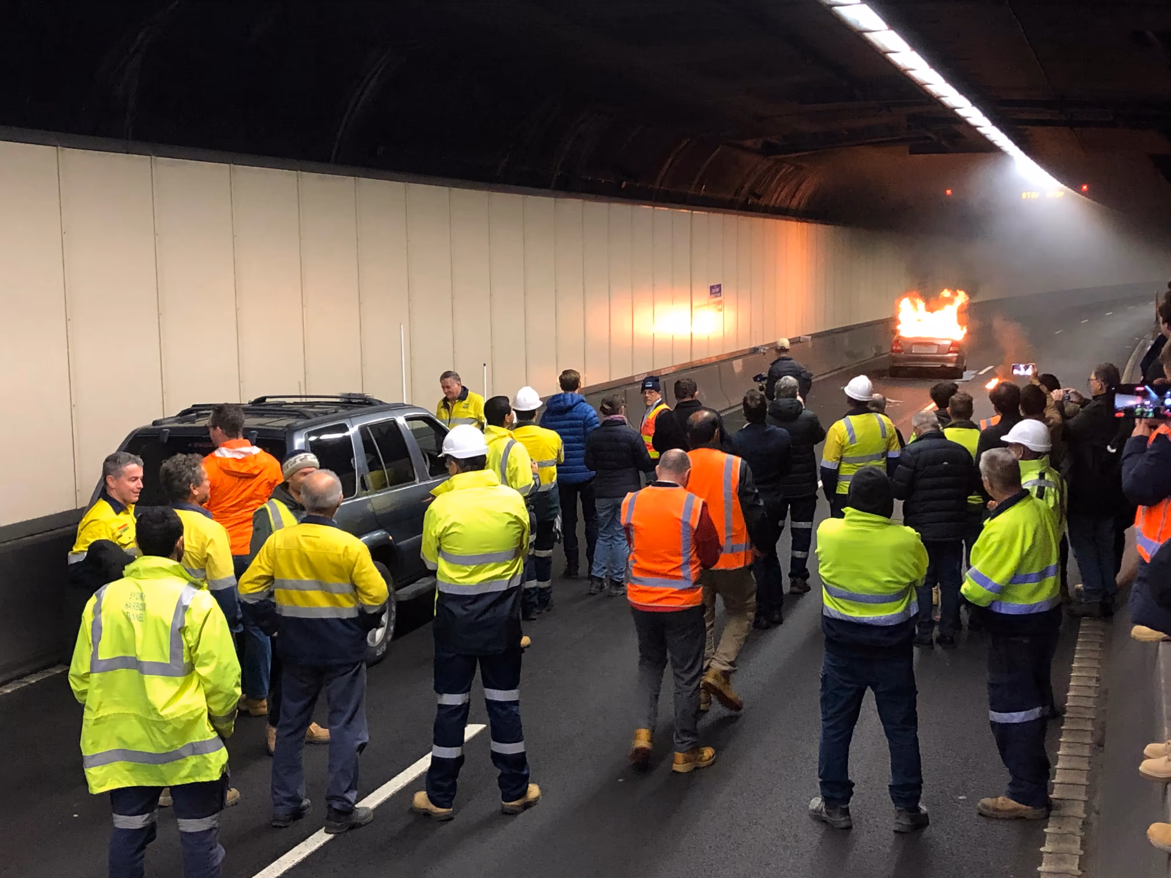Firefighter extinguishes vehicle fire during safety demonstration in Sydney Harbour Tunnel