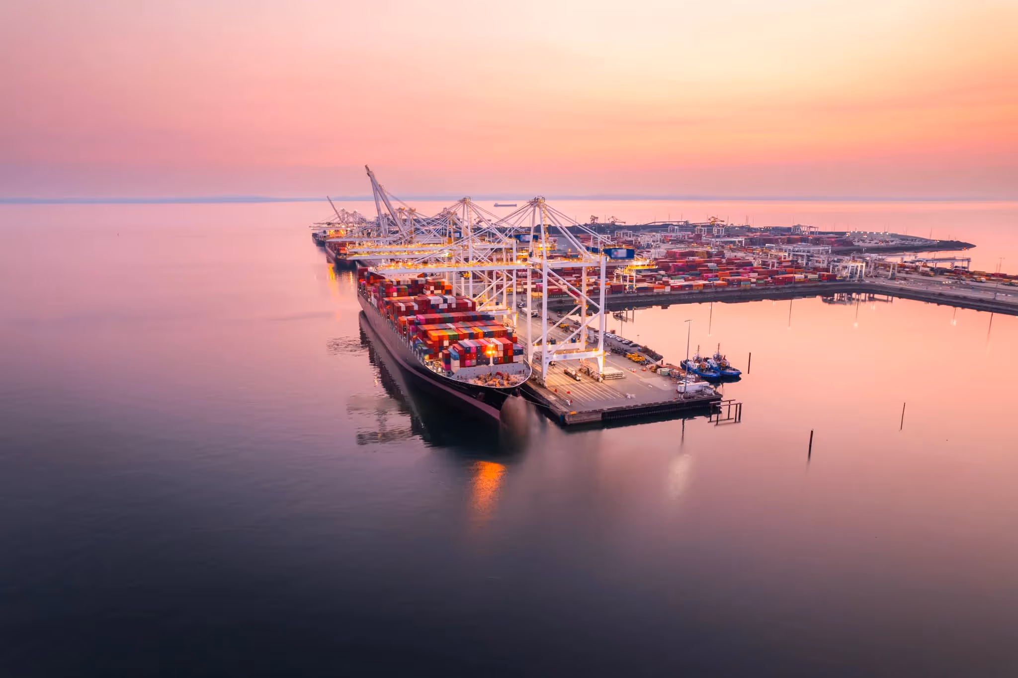 Cargo ship at a port in the ocean at dusk.