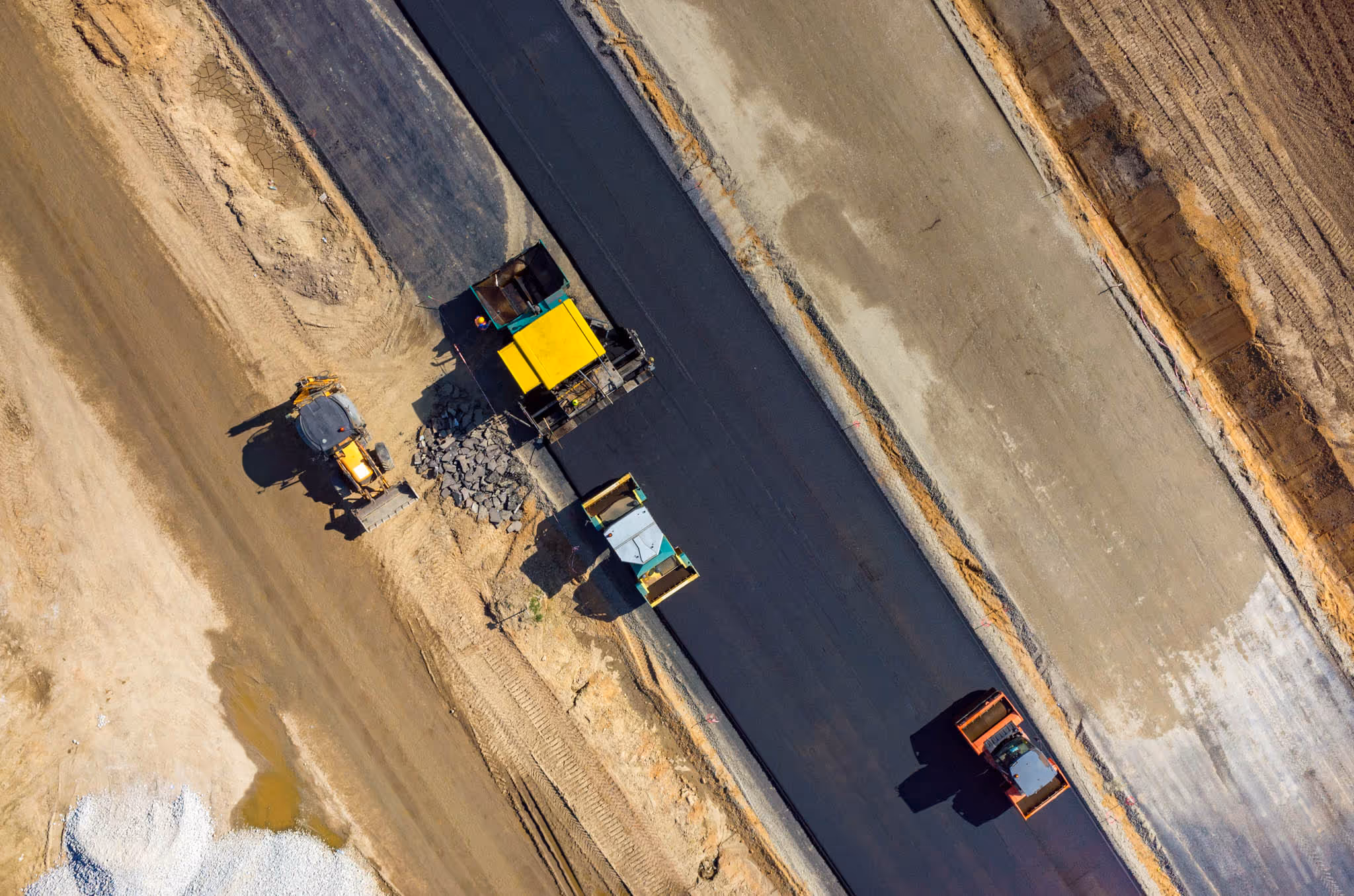 Large vehicles compacting a sealed road