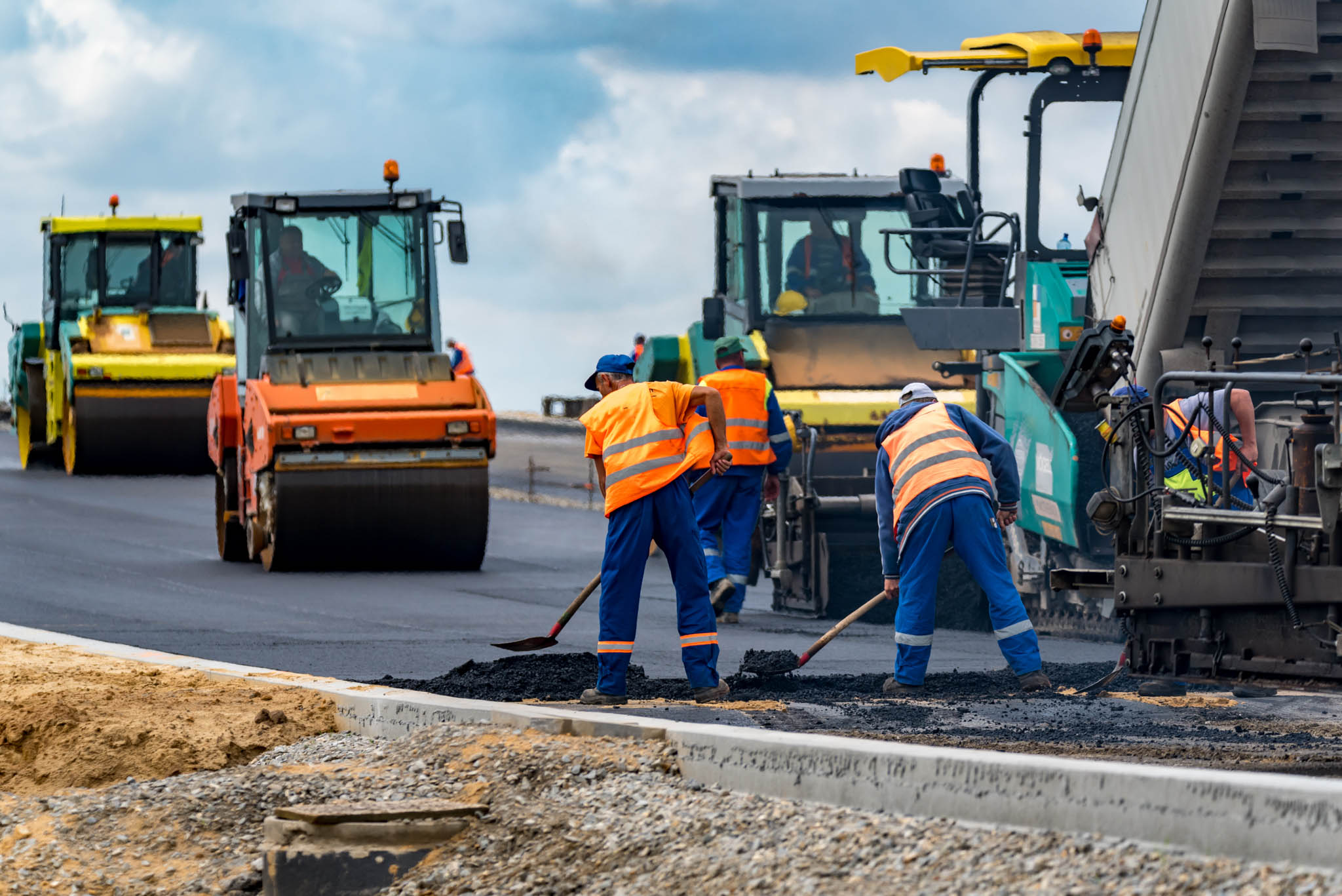 Construction workers putting down a new road pavement.