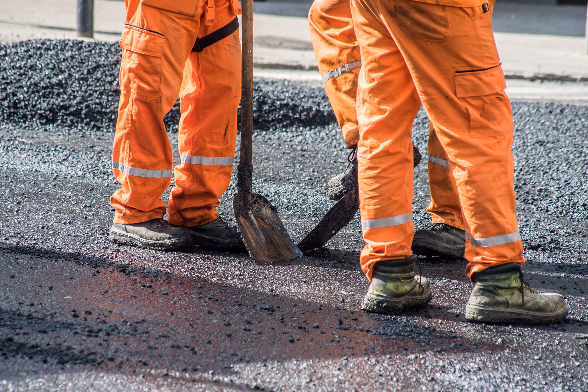 Workers sealing a pavement with asphalt.