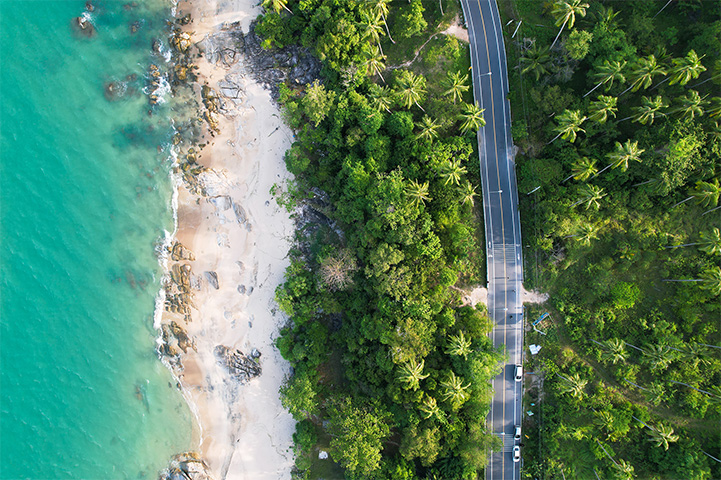Cars on a road along a coastline.