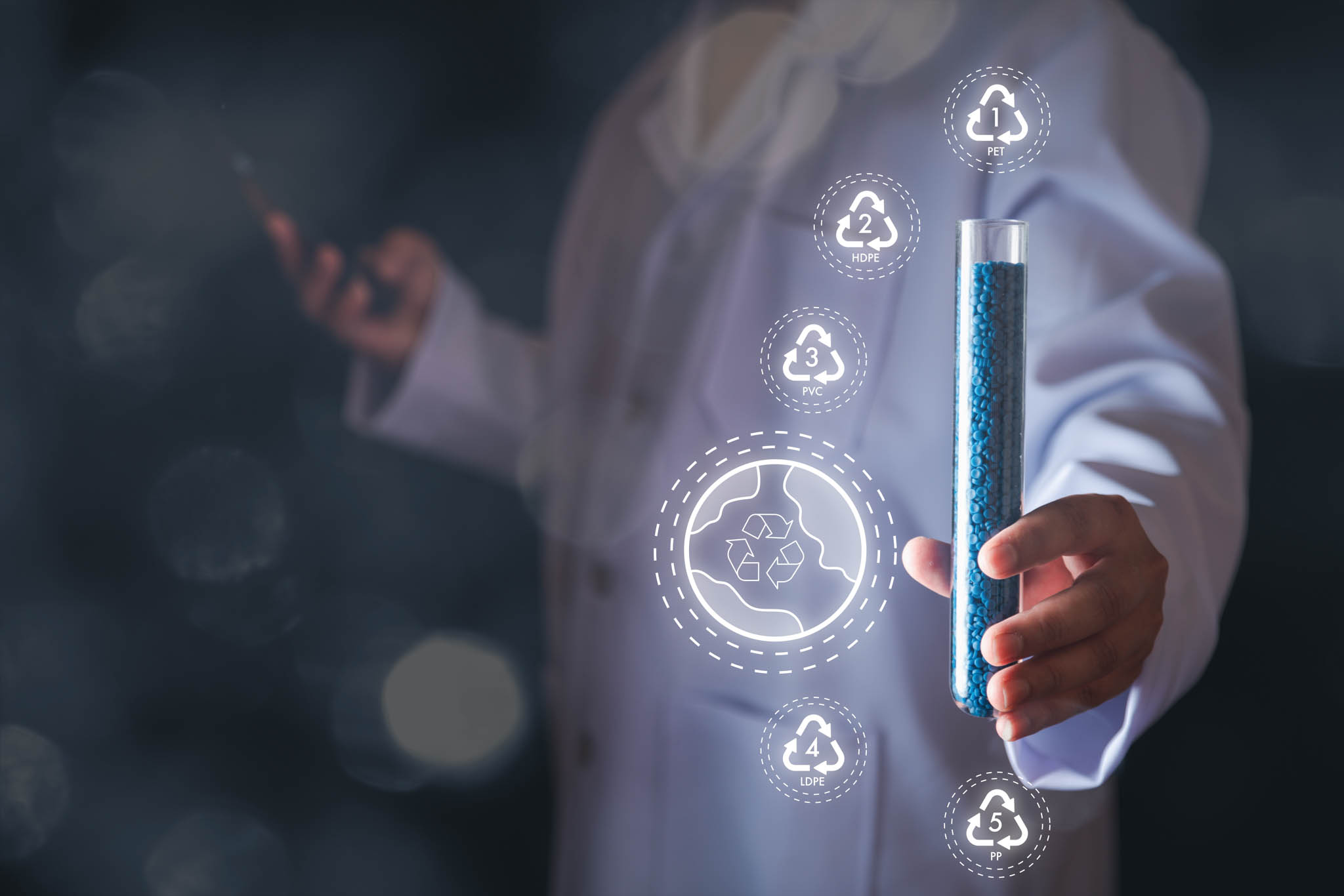 Person in a lab coat holding a tube of recycled materials