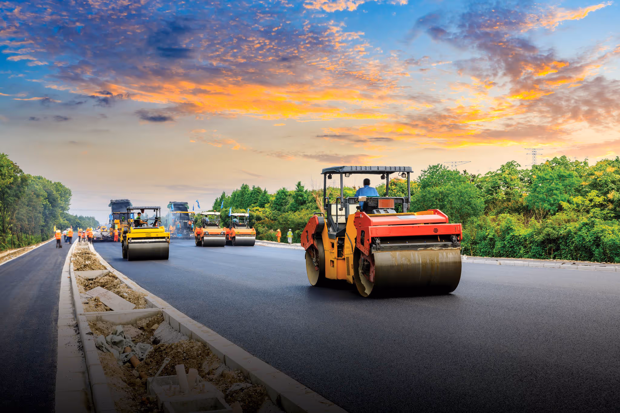 Trucks laying pavement on the road.