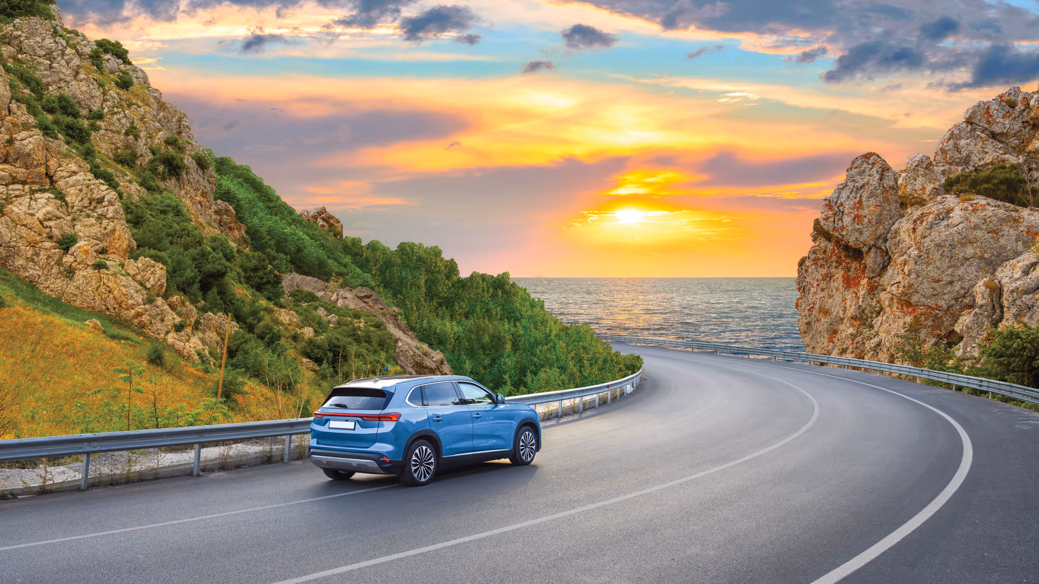 Car driving along a winding paved road.