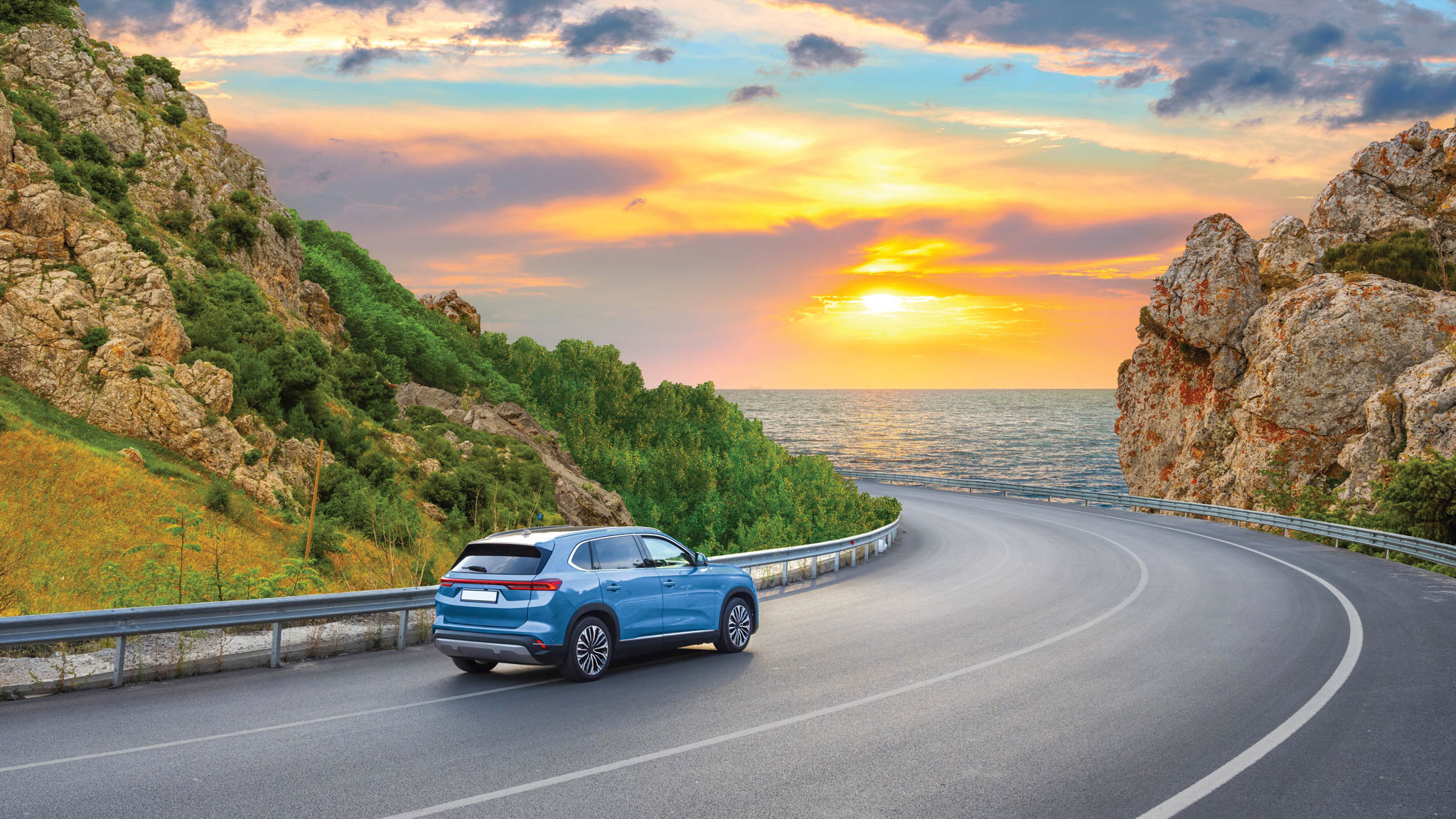 Car driving along a winding paved road.