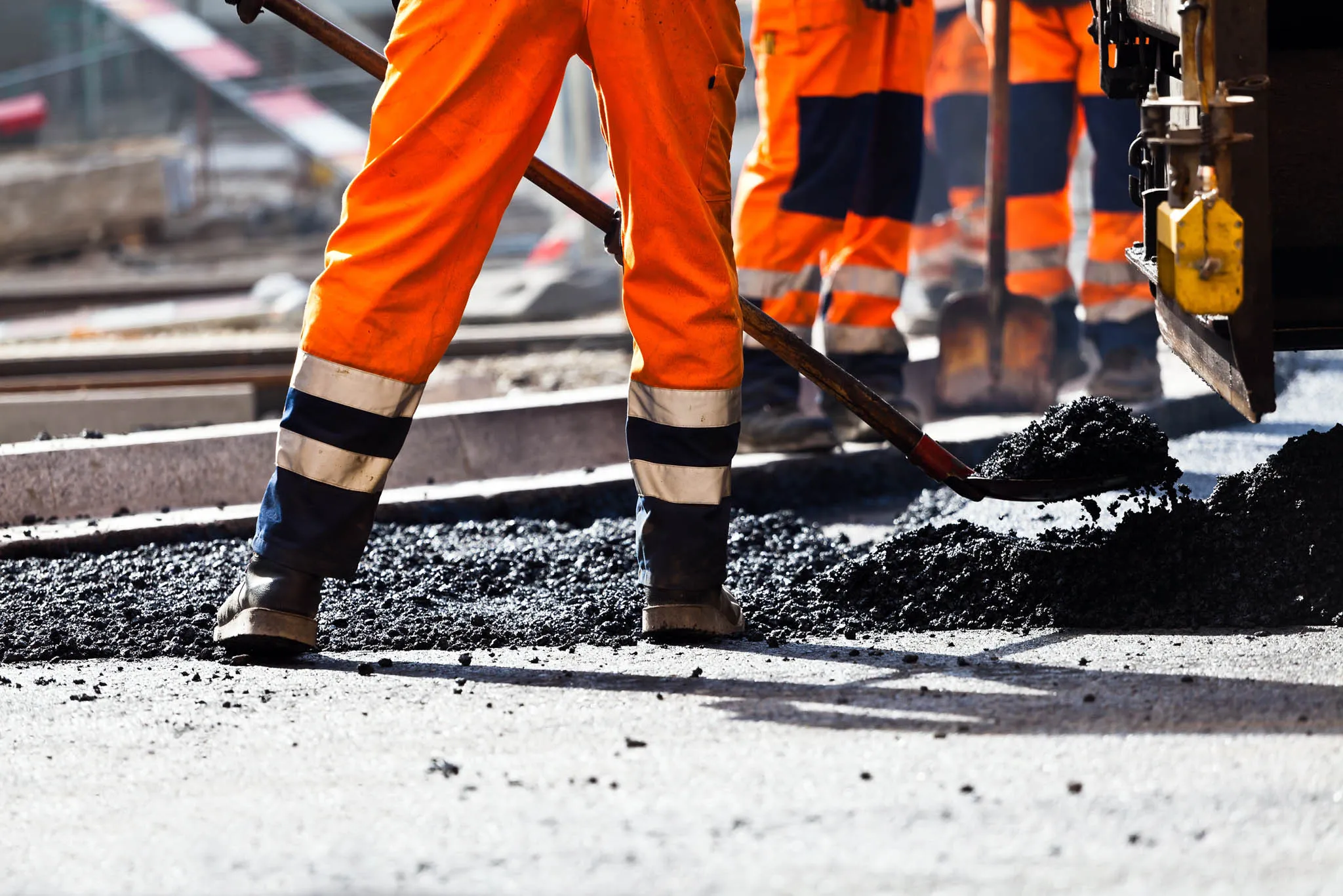 Workers building a road by sealing it with asphalt.
