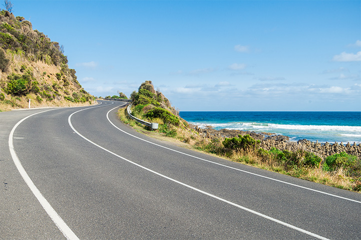 A sealed road winding around a cliffside.