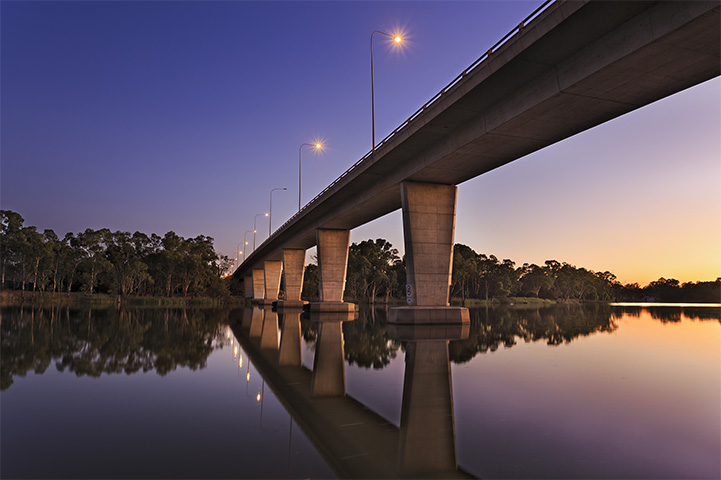 A large bridge over water at dusk.