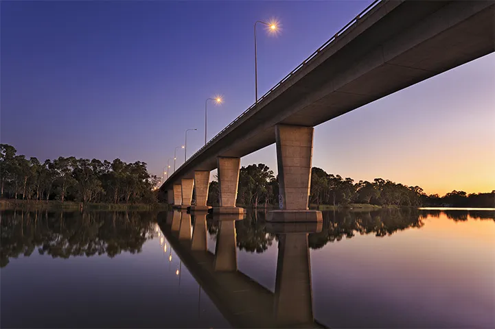 A large bridge over water at dusk.