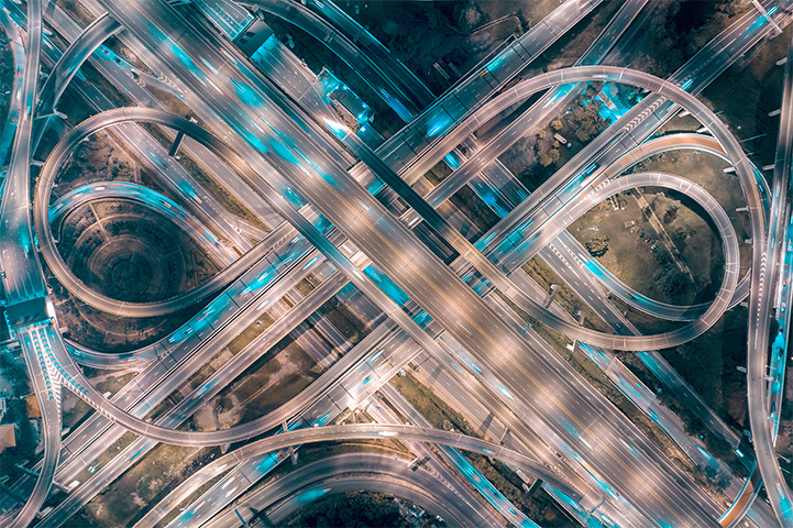 A geometric design of road networks at night with a lot of car lights and street lights.